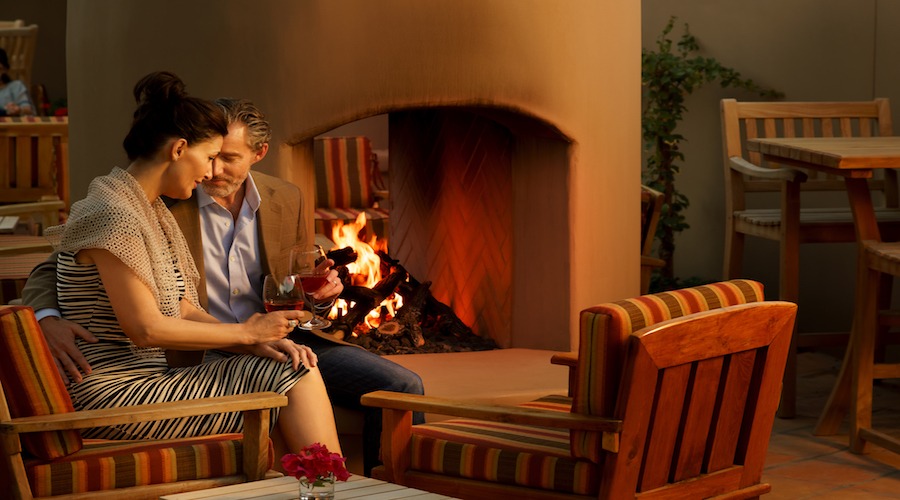 couple drinking by the fireplace